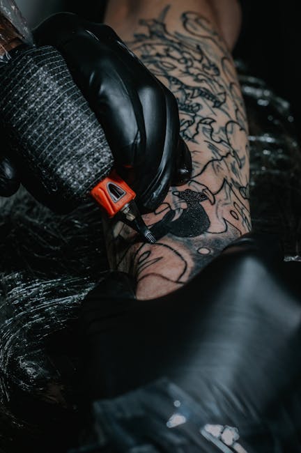 Proceso de tatuaje en detalle con equipo profesional de arte corporal