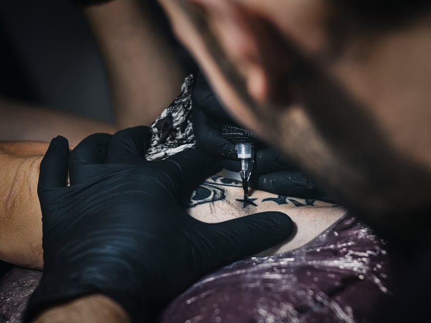 Tatuador profesional trabajando con maquina de tatuar en primer plano